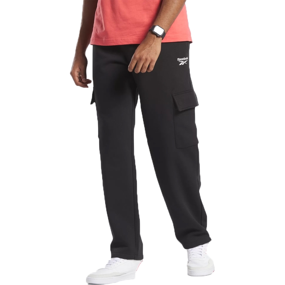 Black Reebok cargo pants paired with white sneakers and a coral T-shirt, featuring a smartwatch on the wrist.