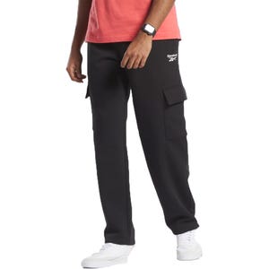 Black Reebok cargo pants paired with white sneakers and a coral T-shirt, featuring a smartwatch on the wrist.
