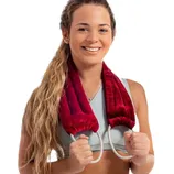 A woman with long hair is holding a maroon neck pad or wrap with two rope-like handles, wearing a light-colored sports bra.