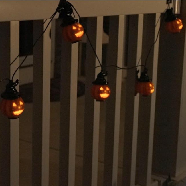 A string of Halloween-themed lights featuring small jack-o'-lanterns with witch hats.