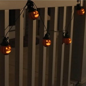 A string of Halloween-themed lights featuring small jack-o'-lanterns with witch hats.