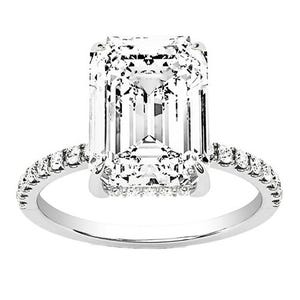 A platinum ring featuring a large rectangular, emerald-cut diamond in the center, with small round diamonds encrusted along the band.