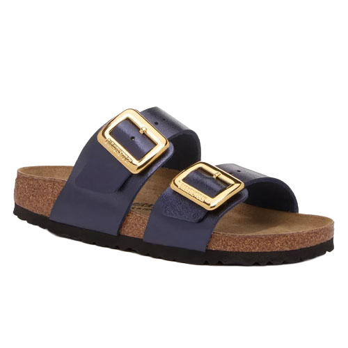 A sandal featuring two navy leather straps with large gold buckles and a cork footbed, designed for comfort and style.