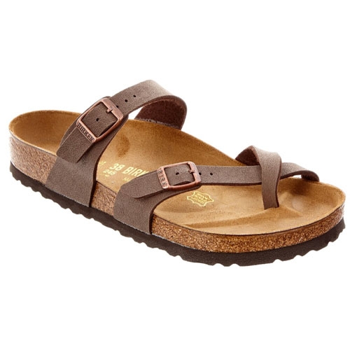 Birkenstock Mayari Sandals feature a cork footbed with two adjustable straps and a toe loop, all in brown with metal buckles. The sandals are designed for comfort and support with a textured sole for grip.