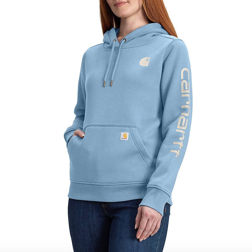 Light blue Carhartt hoodie with a front pocket, Carhartt logo on the chest and sleeve, paired with dark denim jeans.