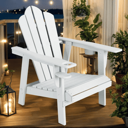 A white Adirondack chair on a wooden deck, surrounded by potted plants, with warm lights glowing in the background.