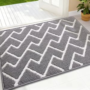 A gray and white chevron-patterned rug is placed near a doorway, with its textured design complementing a bright, open indoor space.
