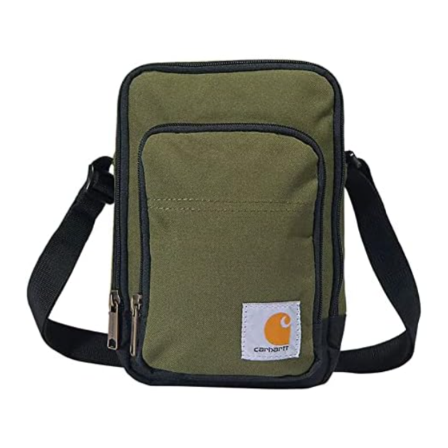 A green shoulder bag with black trim and a front pocket, featuring a Carhartt logo. It has two zippered compartments and an adjustable black strap.