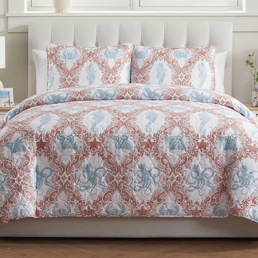 The VCNY Quilt Set features a sea life theme with blue octopuses, starfish, and seahorses against a red intricate pattern on a white background, including a quilt and two matching pillow shams.