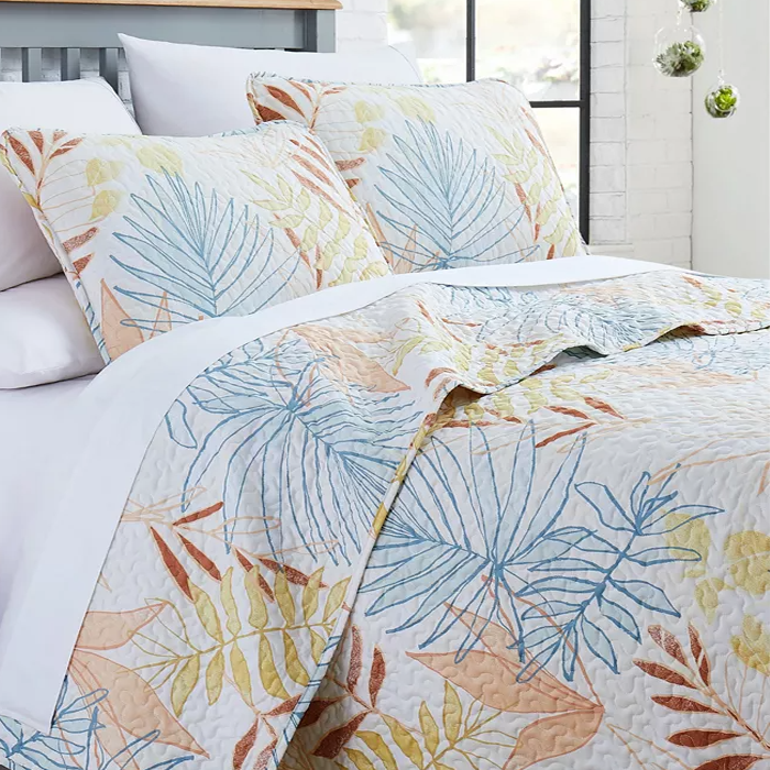 3pc Tropical Leaf Queen Quilt Set features a quilt and two pillow shams with a multicolored leaf pattern in shades of blue, yellow, and orange on a white background, offering a fresh and vibrant look.