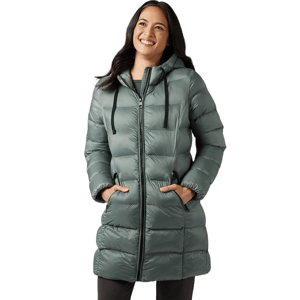 A woman smiling and wearing a green hooded puffer coat with a zipper front and side pockets.