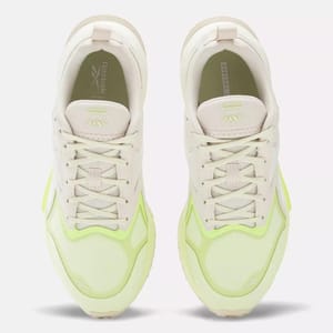 A pair of Reebok sneakers with a beige and neon yellow color scheme.