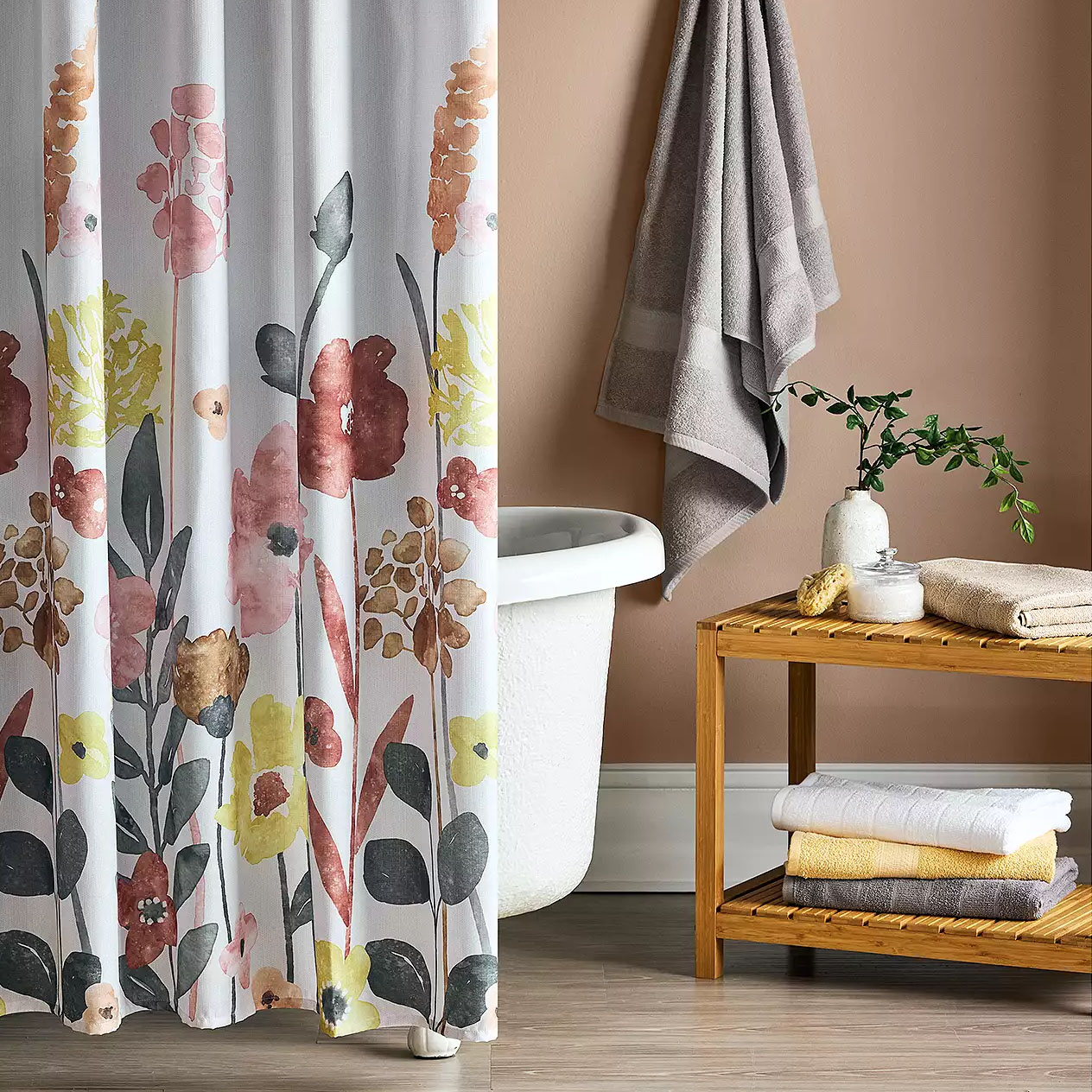 Floral shower curtain featuring a watercolor-style design with pink, yellow, and earthy tones, complementing a neutral bathroom setting.