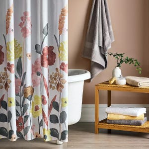 Floral shower curtain featuring a watercolor-style design with pink, yellow, and earthy tones, complementing a neutral bathroom setting.