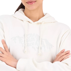 A person wearing a white hoodie with \“The North Face\“ logo on the front. The individual has crossed arms and glossy lips.