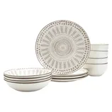 A set of beige ceramic dinnerware with intricate circular patterns, including plates and bowls, organized in a stack.
