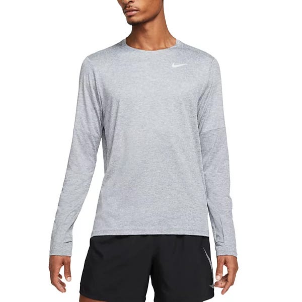 Nike Men's Dri-FIT Tee is a long-sleeve, light gray shirt with a small Nike logo on the left chest, designed for athletic use. It's paired with black shorts, suitable for running or training activities.