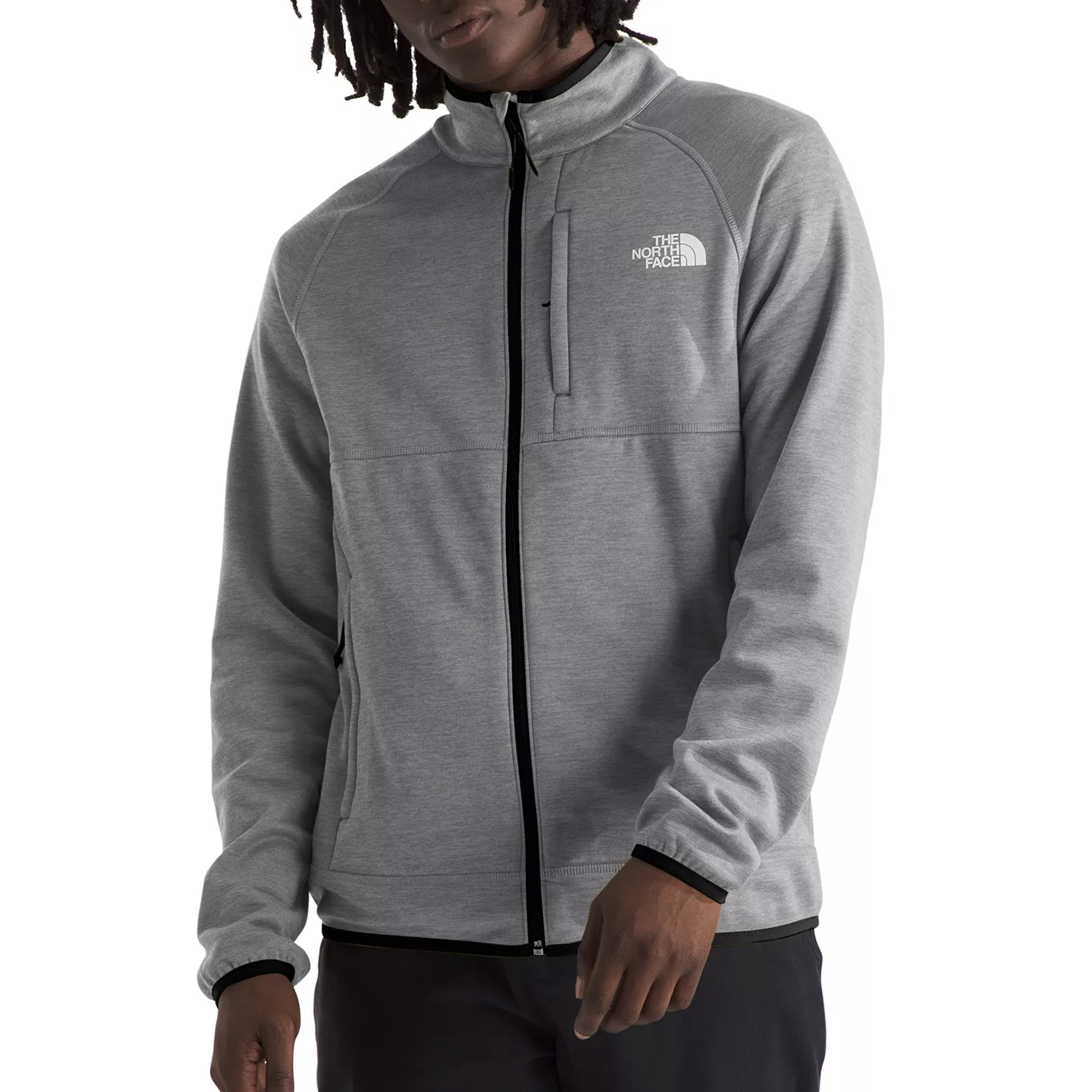 A person wears a gray fleece jacket with a full front zipper and pockets, featuring The North Face logo on the chest.