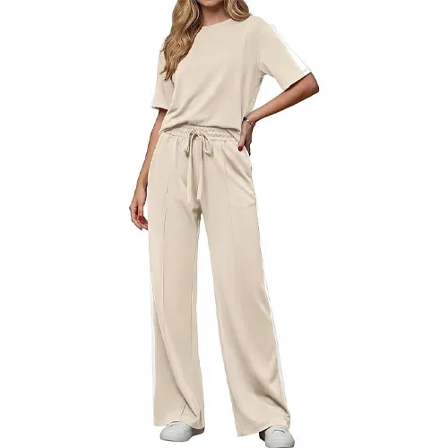 A beige two-piece outfit featuring a short-sleeve top and wide-leg pants with a drawstring waist, paired with white sneakers.