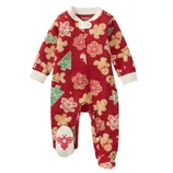 Red baby sleeper with holiday-themed prints, including gingerbread men, Christmas trees, and snowflakes, featuring a front zipper and a bee design on one foot.
