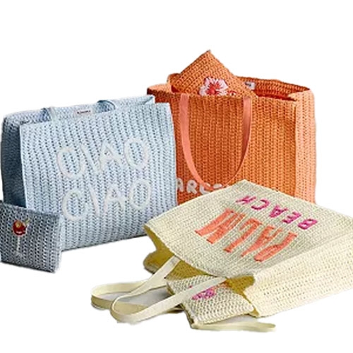 Three woven tote bags in blue, orange, and cream with text \“CIAO CIAO,\“ floral patterns, and \“BEACH\“ are displayed, along with a small folding fabric bag.