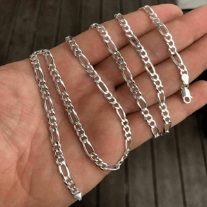 A silver Figaro chain is shown, featuring a pattern of three small circular links followed by one elongated oval link, with a lobster clasp for fastening.