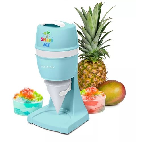 A pastel blue Nostalgia Shave Ice Maker with a funnel attachment is shown alongside colorful shaved ice cups, a pineapple, and a mango.