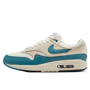 A pair of Nike Air Max 1 sneakers with a beige and teal color scheme, featuring a visible Air unit in the sole.