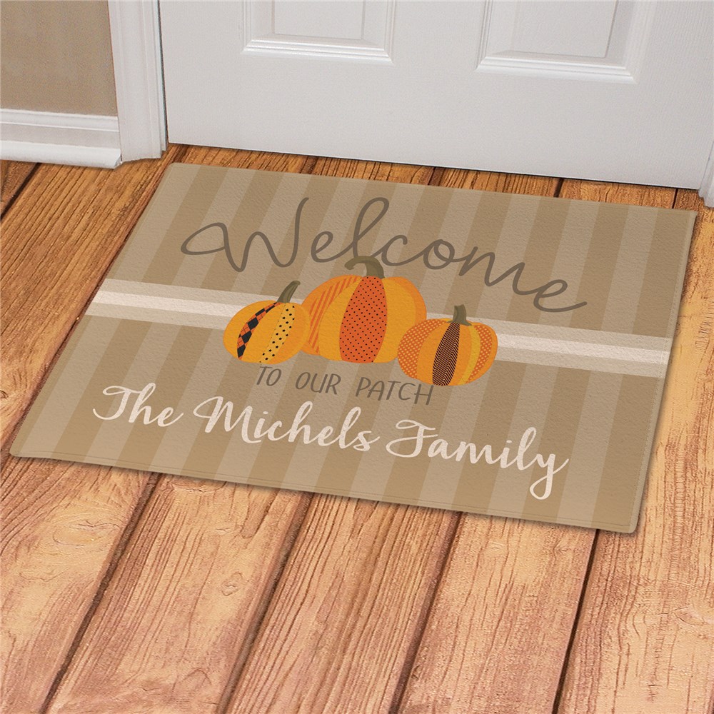 A personalized doormat with \“Welcome to our patch\“ text and pumpkin graphics, customized with \“The Michels Family.\“