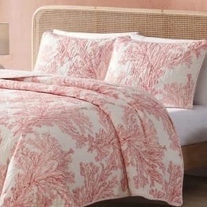 A Tommy Bahama queen quilt set featuring a white background with a coral pink coral reef design. The set includes a quilt and two matching pillow shams.