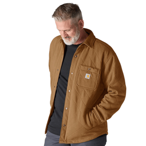 A man wearing a brown quilted Carhartt shirt jacket with snap buttons, featuring a visible pocket logo on the chest, over a black shirt.