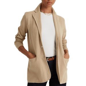 A beige Ralph Lauren sweater-knit blazer with notched lapels, long sleeves, patch pockets, and a single-button closure, worn over a white top with dark jeans and a brown belt.