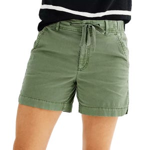 Green shorts with a drawstring waist and side pockets, paired with a black and white striped top.