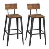 A pair of barstools with distressed wooden seats and backs, supported by black metal frames. They feature footrests and have a rustic industrial style.