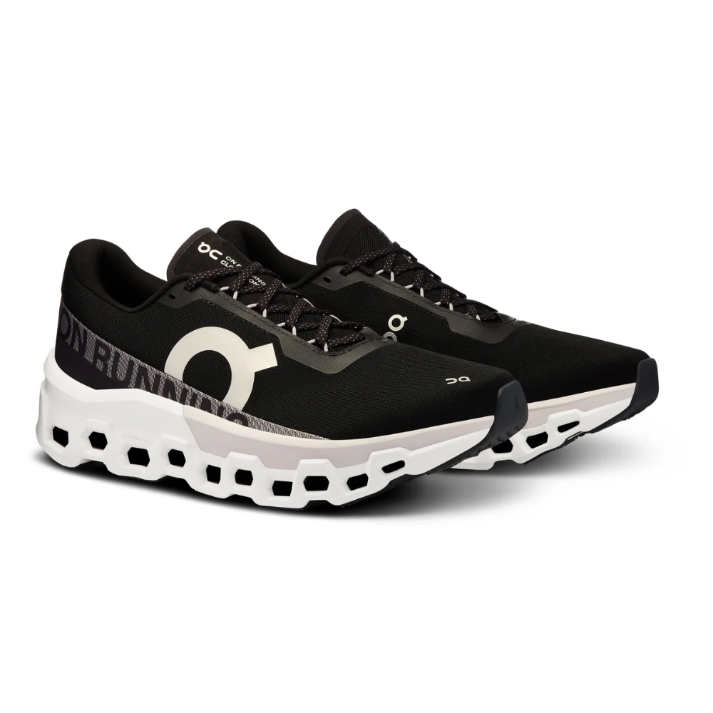 Black athletic shoes with a distinctive white sole featuring circular cutouts, designed by On Running.