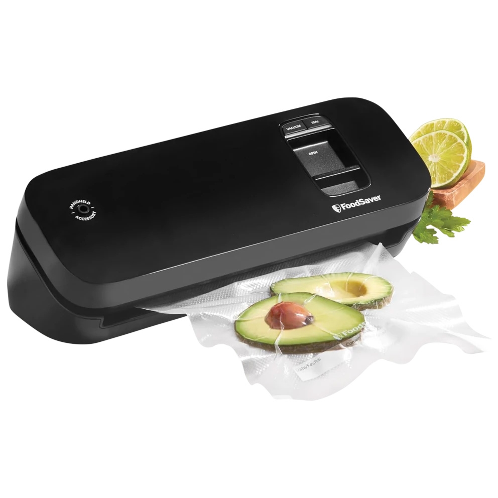 A black FoodSaver vacuum sealing machine is shown with a sealed bag containing avocado slices. A lime and parsley are placed beside it.