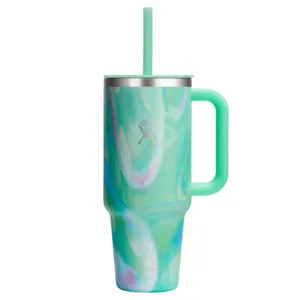 A mint green Hydro Flask tumbler with a swirling pattern, featuring a handle and a straw, designed for keeping drinks insulated.