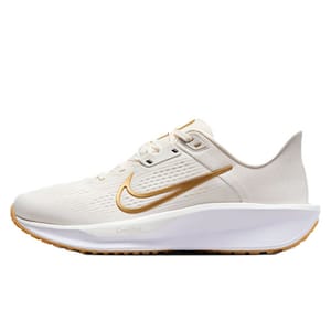 A white athletic shoe features a gold swoosh logo, breathable mesh upper, and cushioned sole for comfort.