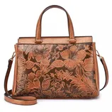 A brown leather handbag with floral embossing, featuring short handles and a detachable long strap for versatile carrying options.