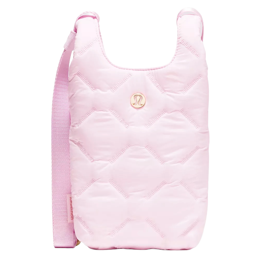 A pink quilted crossbody bag featuring the Lululemon logo with an adjustable strap.