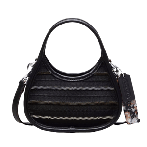 A black handbag with a unique silhouette features horizontal zipper detailing and comes with a detachable strap and a decorative tag.