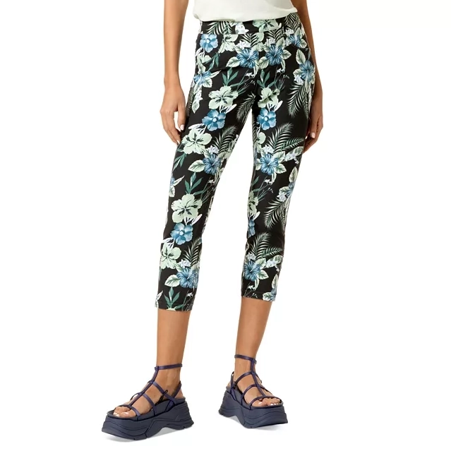 Capri leggings featuring a tropical floral and leaf pattern in shades of blue, green, and white, paired with dark blue strappy platform sandals.