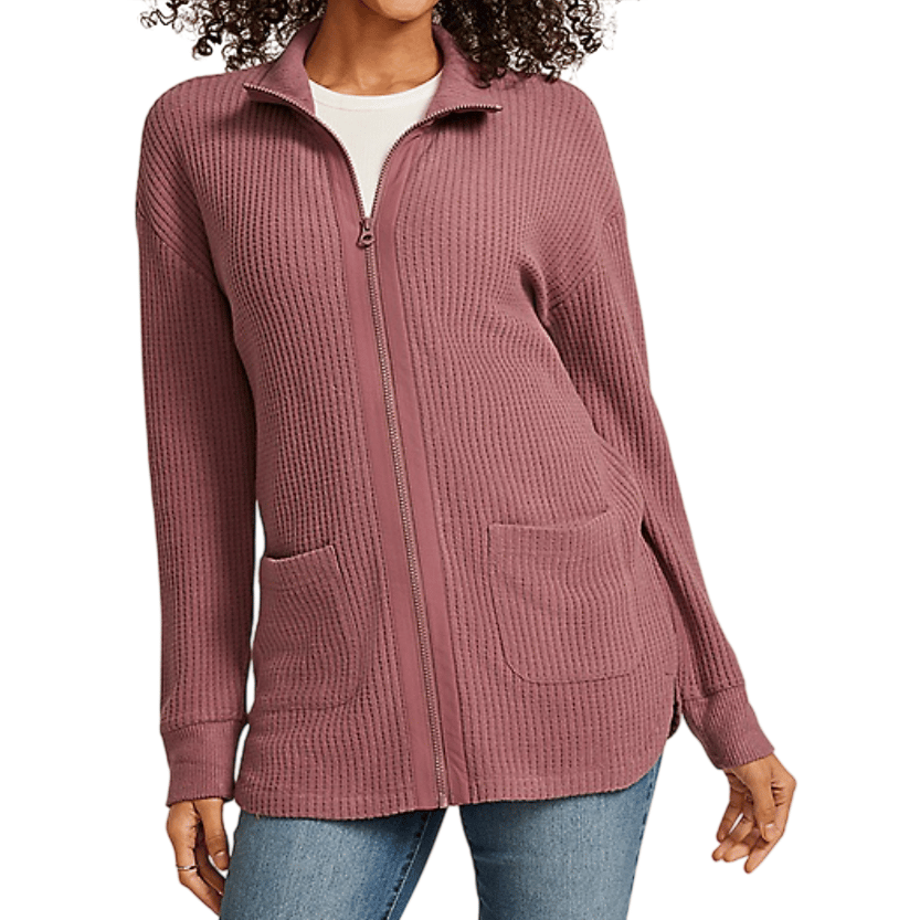 A mauve zip-up cardigan with a waffle-knit texture, featuring a full front zipper and two front pockets, paired with blue jeans.