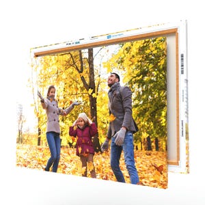 A canvas print featuring a family enjoying a walk in an autumnal park, with vivid yellow leaves on trees and ground.