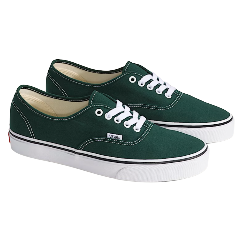 A pair of green Vans sneakers with white laces, featuring white stitching on the canvas upper and a white rubber sole with a black stripe.