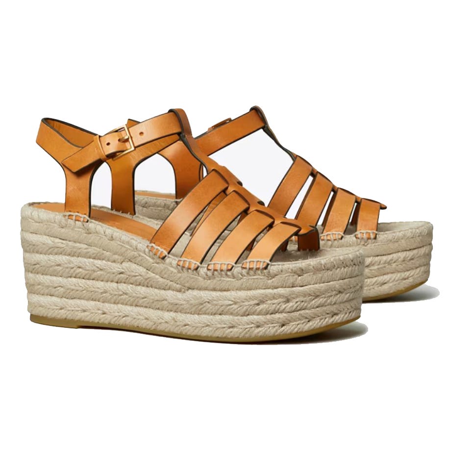 A pair of tan strappy wedge sandals with a braided espadrille platform.