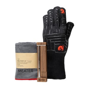 The MEATER Pro SmartThermometer Bundle includes a wireless meat thermometer, a gray microfiber towel, and a black heat-resistant glove with an orange logo.