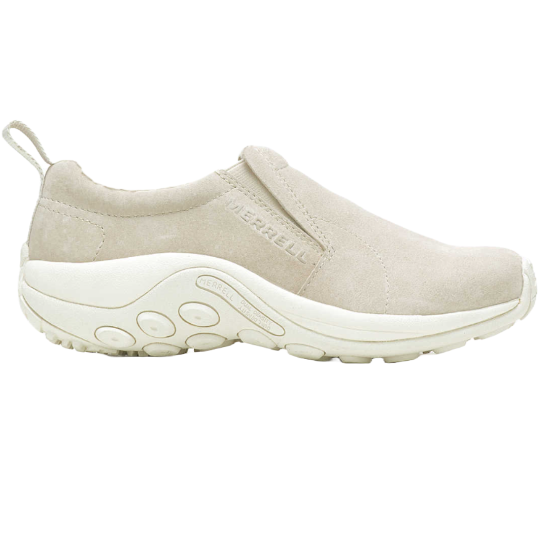 Merrell Women's Jungle Moc Cozy Shoes feature a slip-on design with a suede upper in a light beige color, and a cushioned, contoured white sole for comfort and casual wear.