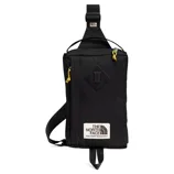 Black sling bag with yellow zipper pull tabs and a \“The North Face Fine Alpine Equipment\“ label.