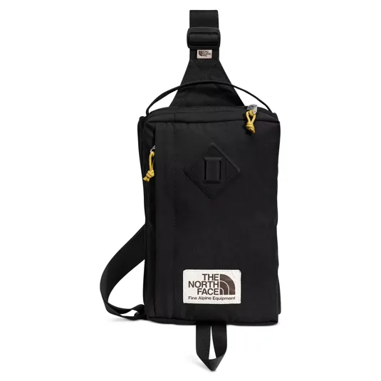 Black sling bag with yellow zipper pull tabs and a \“The North Face Fine Alpine Equipment\“ label.